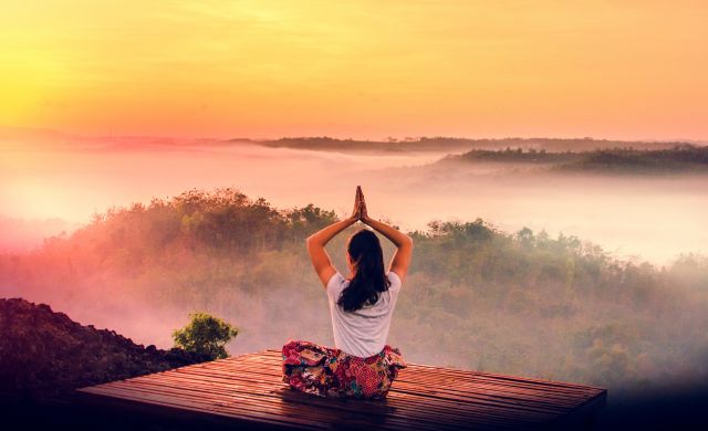 Woman_Practicing_Yoga_at_Sunrise_Over_Rainforest