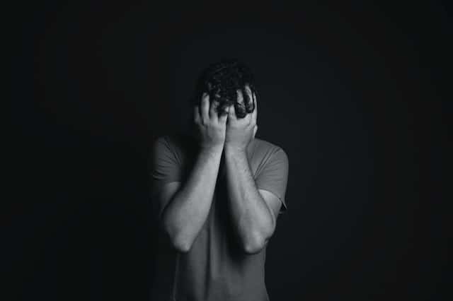 gray-scale-photo-of-man-covering-face-with-his-hands