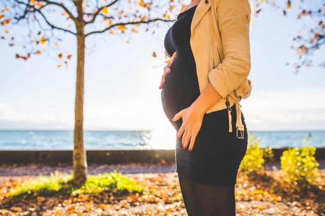 pregnant-woman-wearing-beige-long-sleeve-shirt-standing